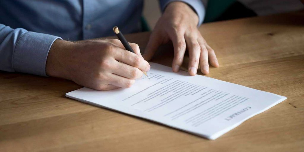Man signing a professional liability insurance policy