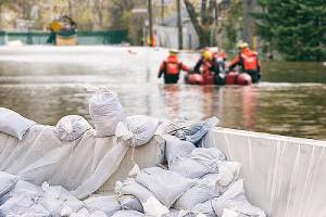 Flood Protection Sandbags with flooded street in the background.Flood insurance can protect a home or business.