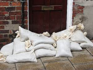 Sandbags stacked as flood barrier in front of door used in place of flood insurance for renters