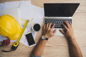 man on the computer looking up Cost Of Contractors Insurance