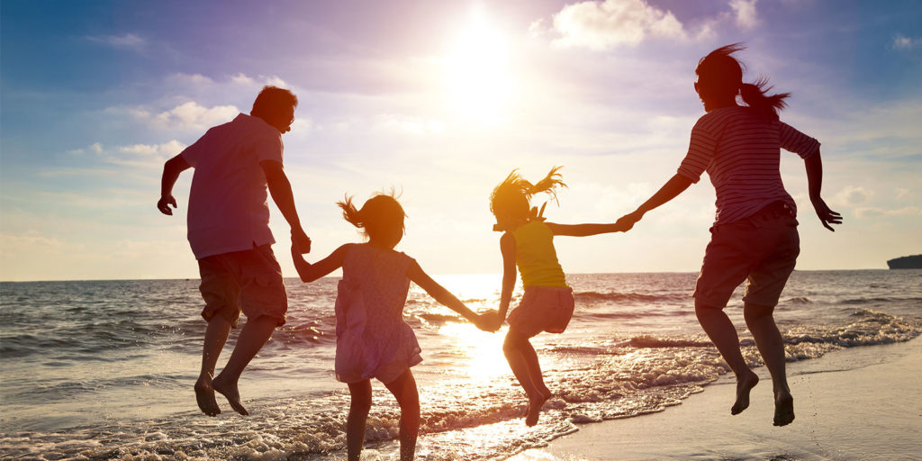 family on a beach holding hands