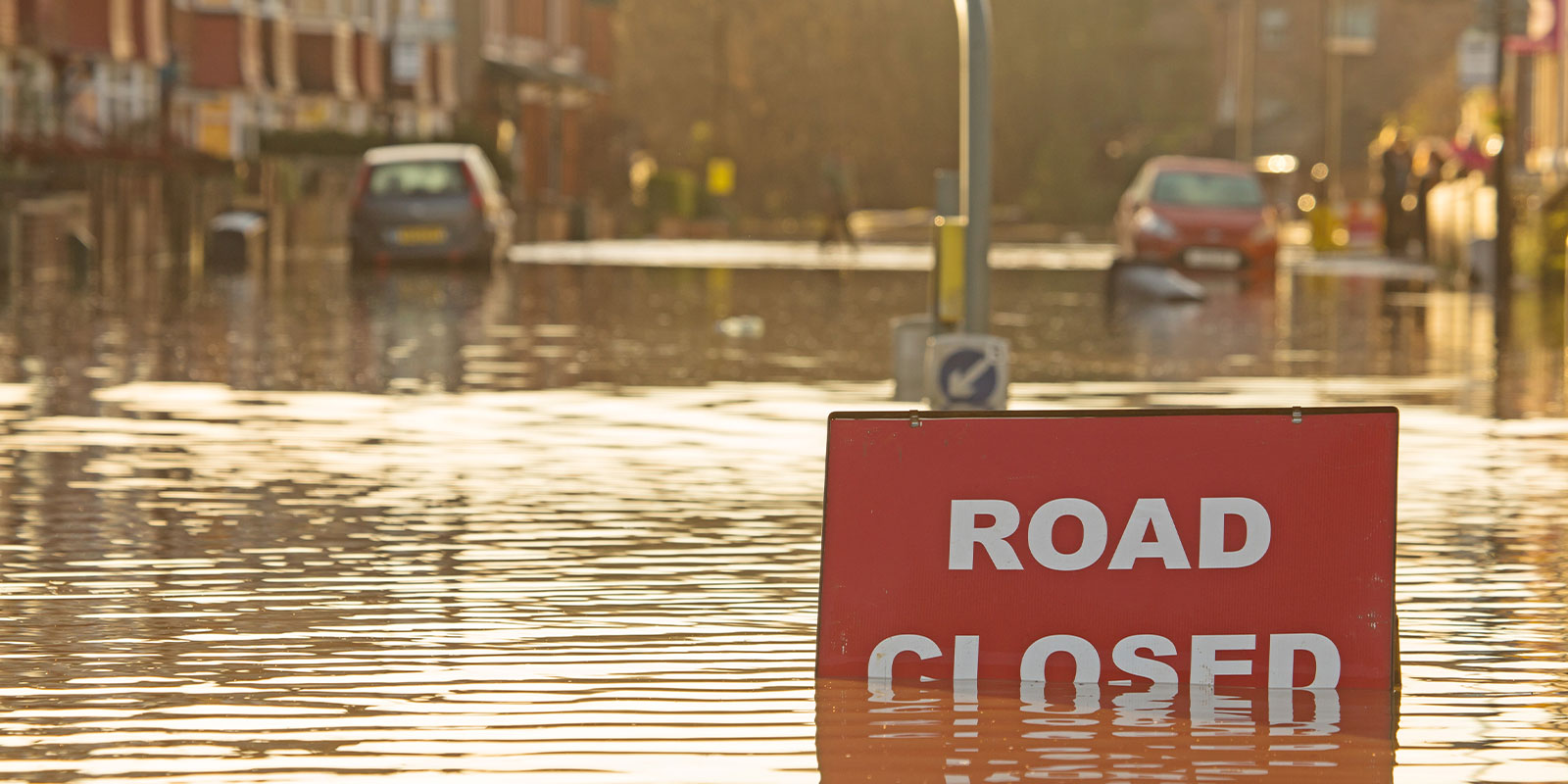 a flooded road closed sign with fema flood insurance