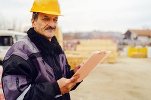 Contractor covered with General Contractor Insurance Wearing Yellow Holding List