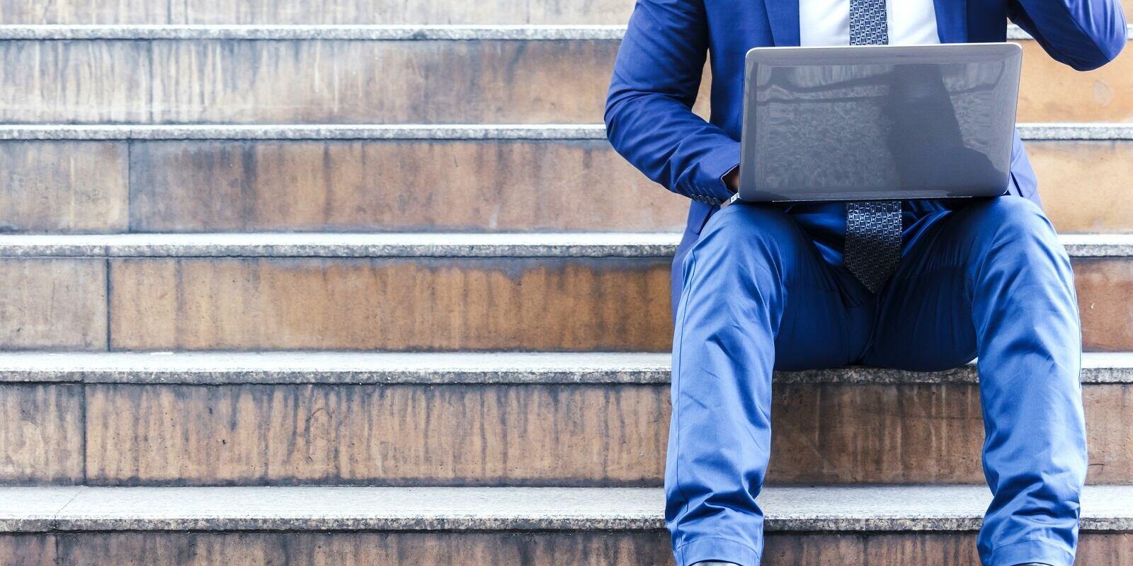 Need Insurance As An Independent Contractor- Businessman Sitting on Stairs with Laptop