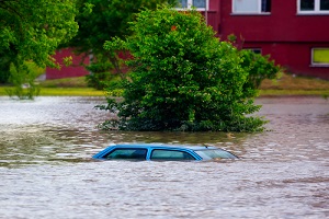 blue car having commercial flood insurance drowned in water