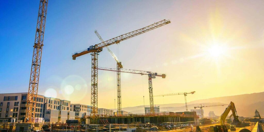 large construction site including several cranes working on a building complex