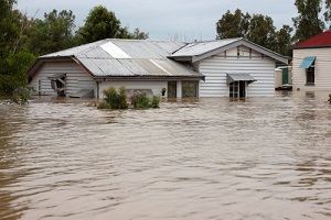 timber country home with water up the windows of building with commercial flood insurance
