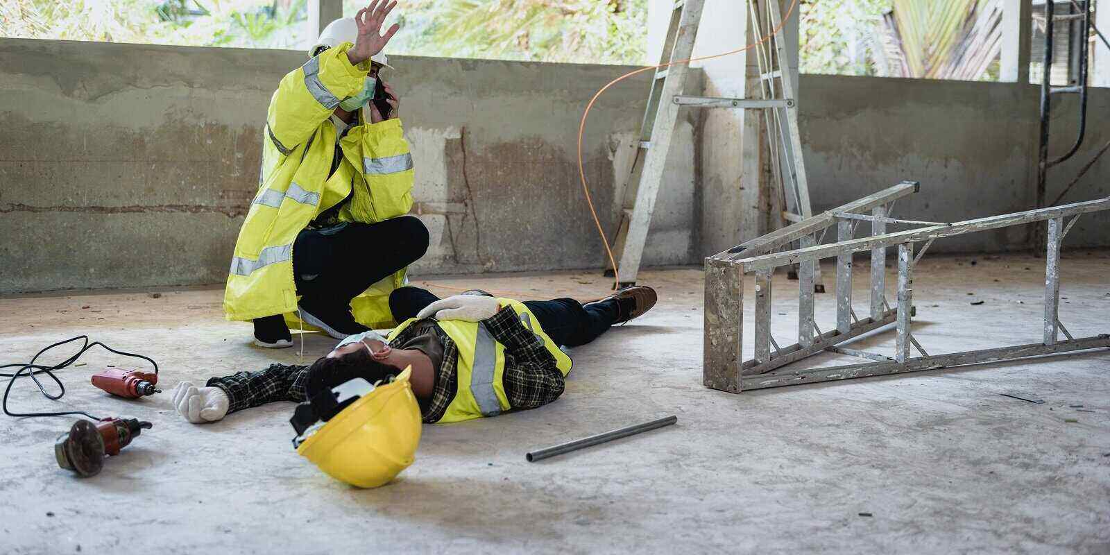 construction worker calling help for injured friend