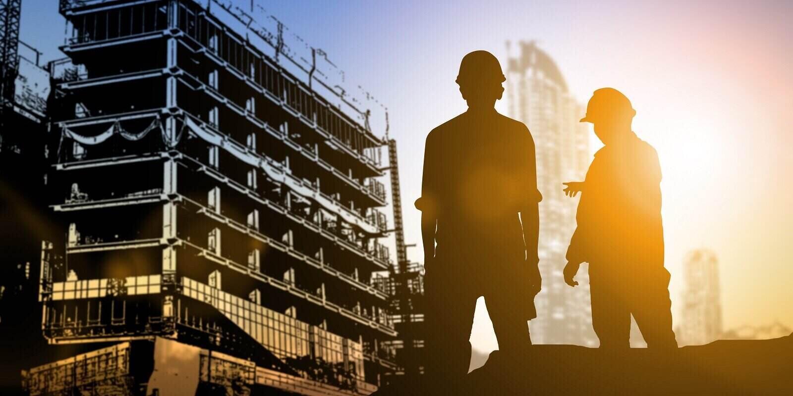 engineer looking blueprint in a building site over Blurred construction site