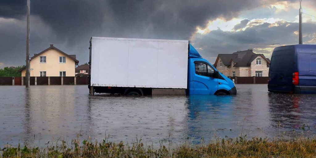 car rides in heavy rain on a flooded road