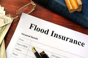 flood insurance form on a table with a book with info on flood insurance for commercial property
