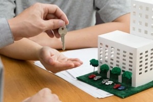 man giving keys to another man with condominium association insurance