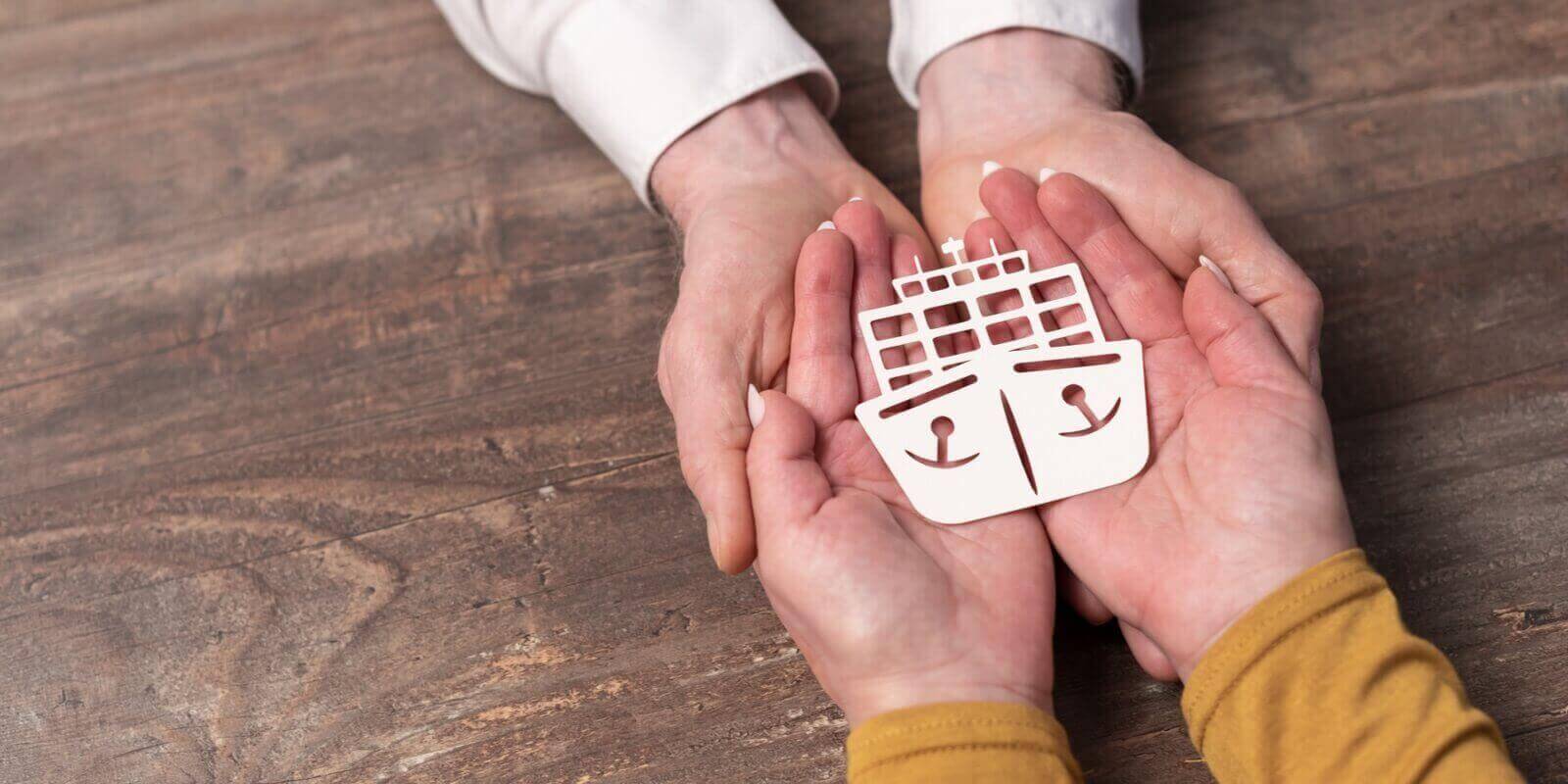 marine insurance with paper ship in hands