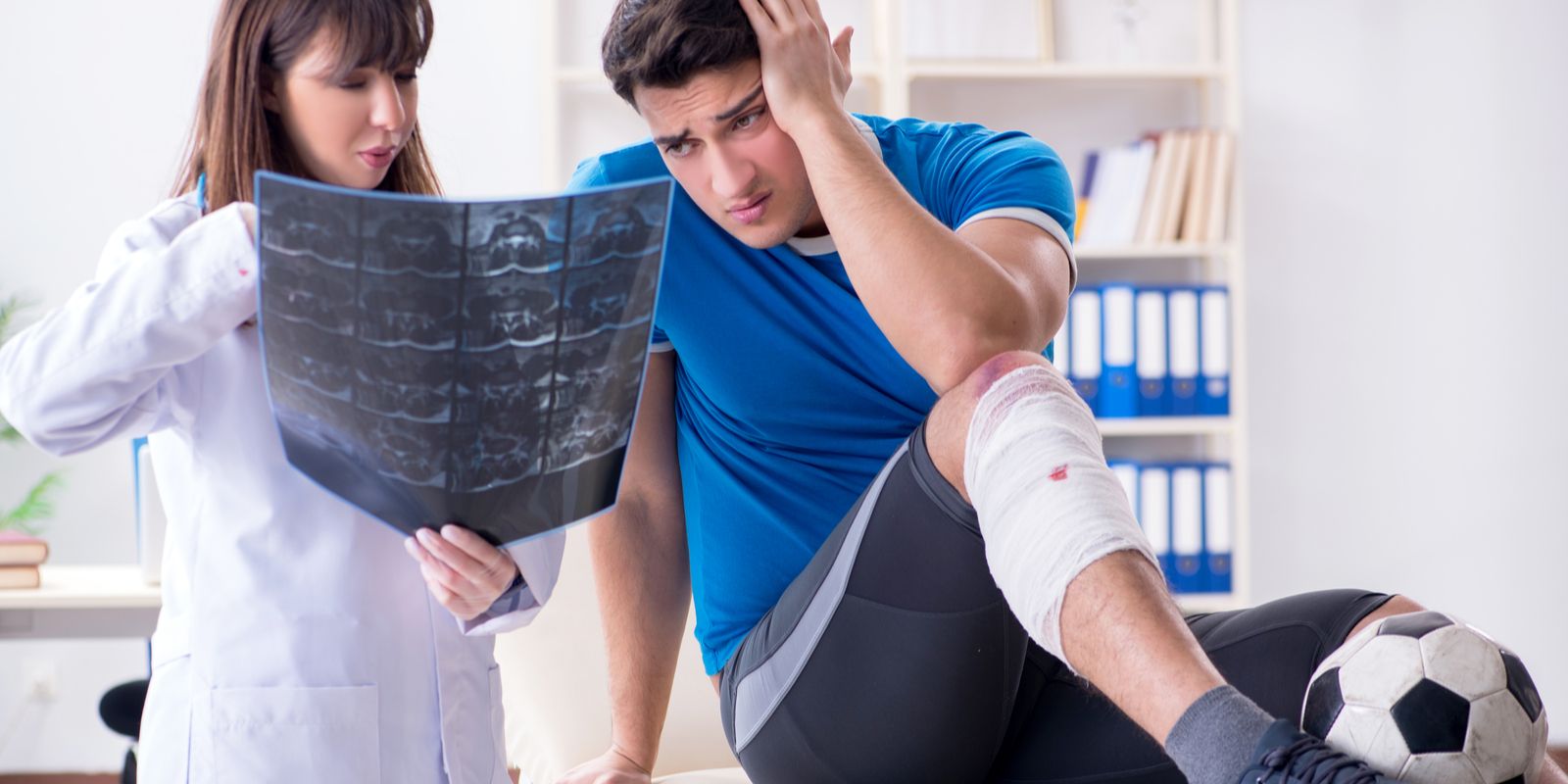 An sports insured football player consulting his doctor about leg injury