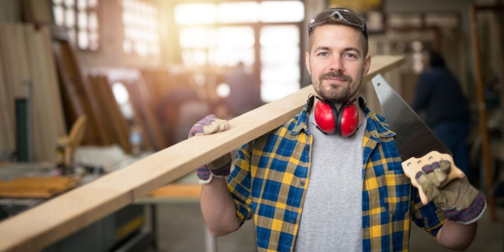 professional middle aged carpenter with wood plank