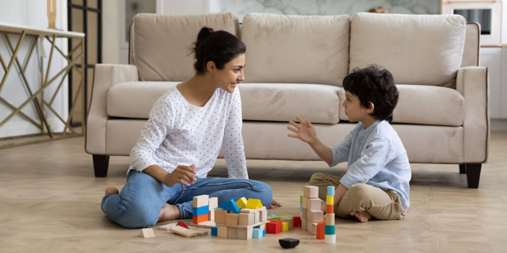 young Indian mother and little son playing together on heating floor