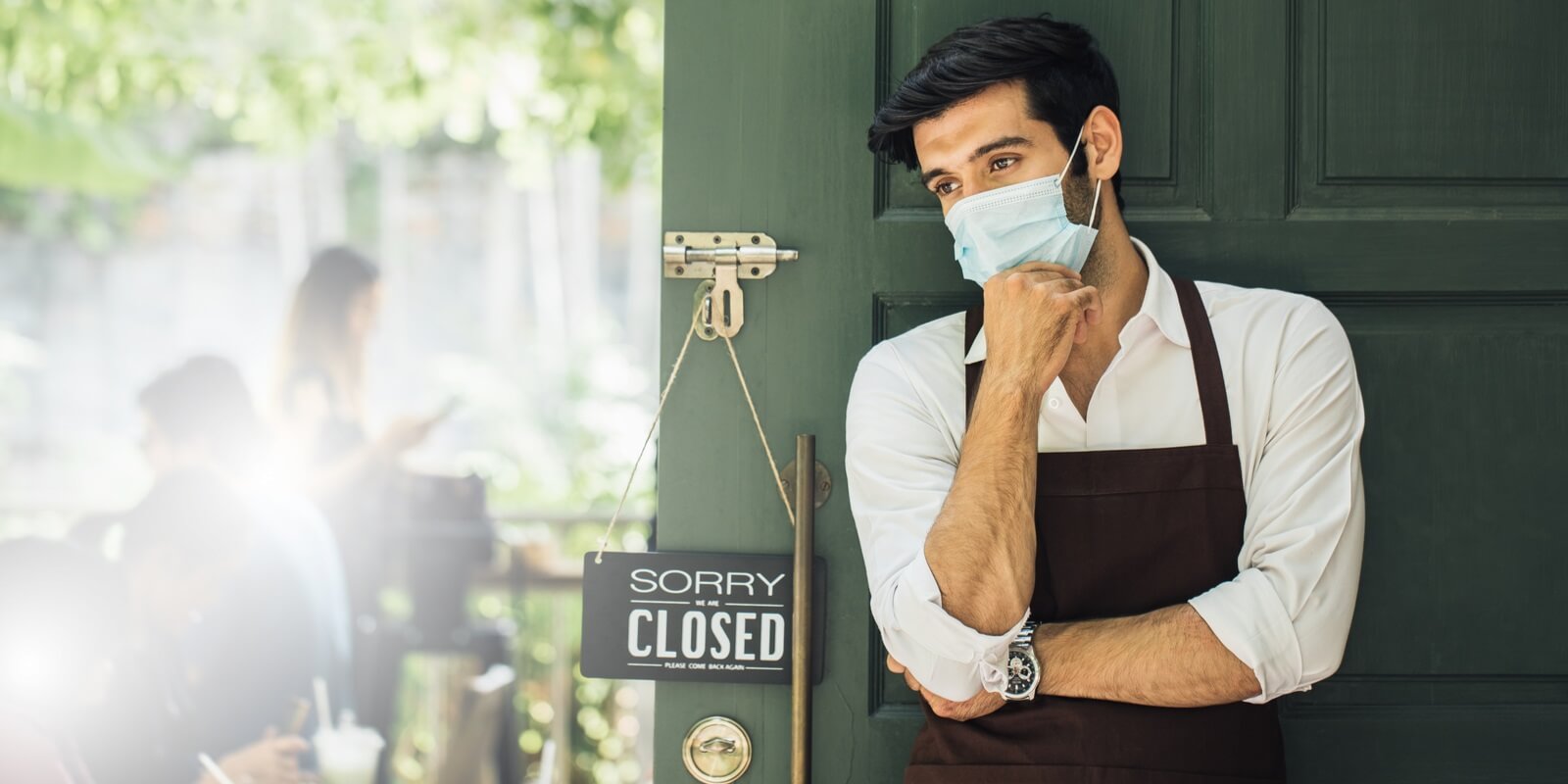 businessman has sad mood with closed sign board hanging on the door of cafe