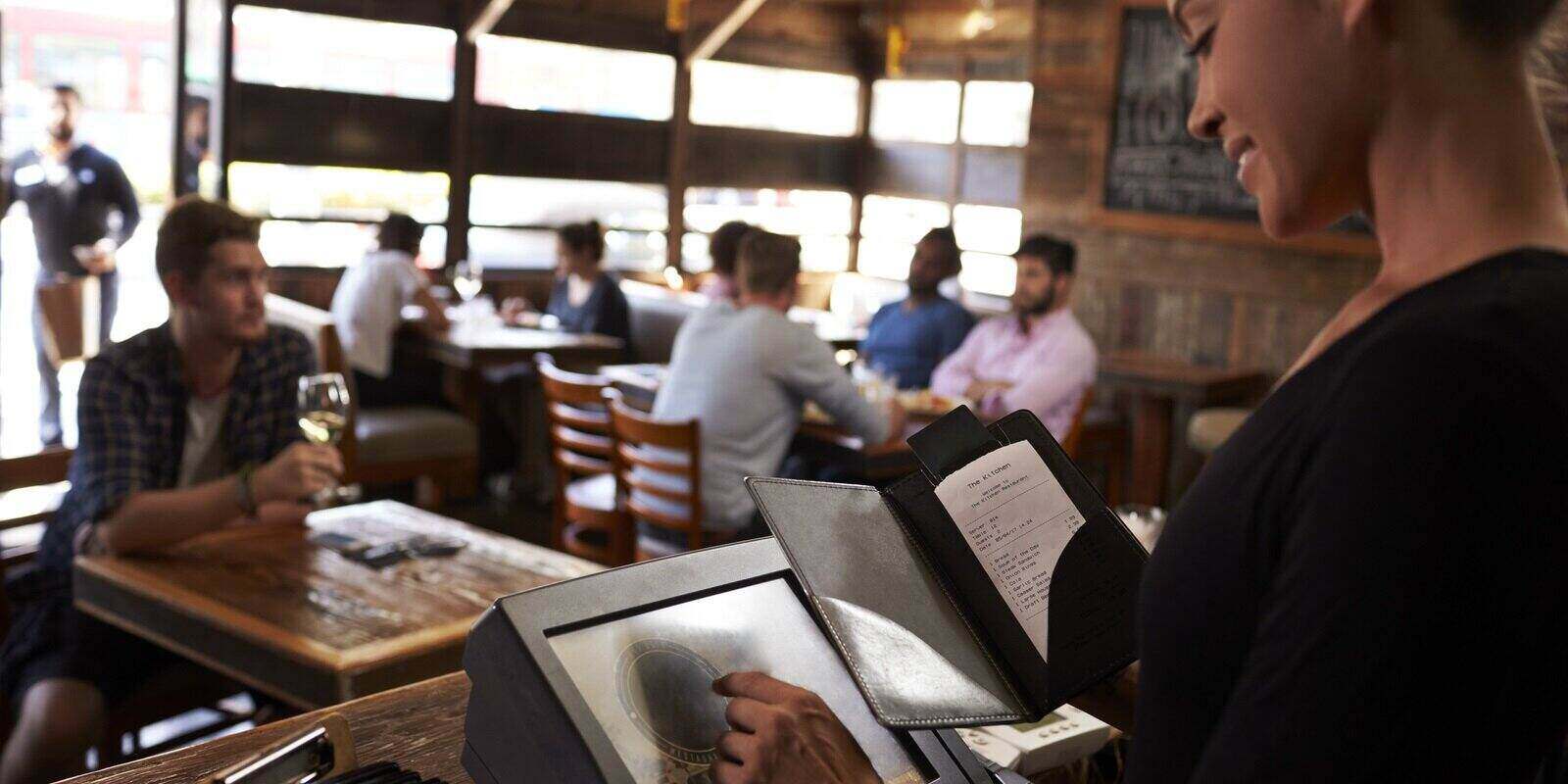 woman preparing bill at restaurant using touch screen