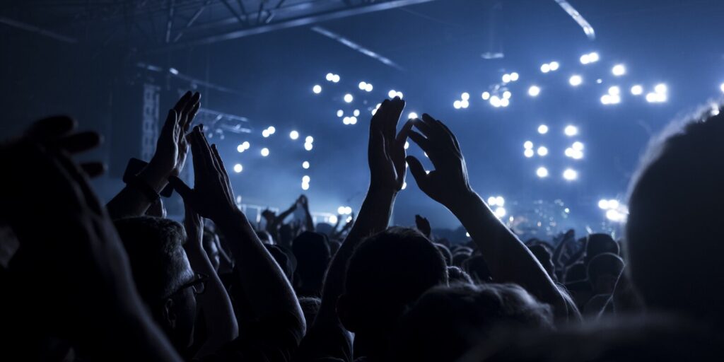 concert goers applauding inside a music venue