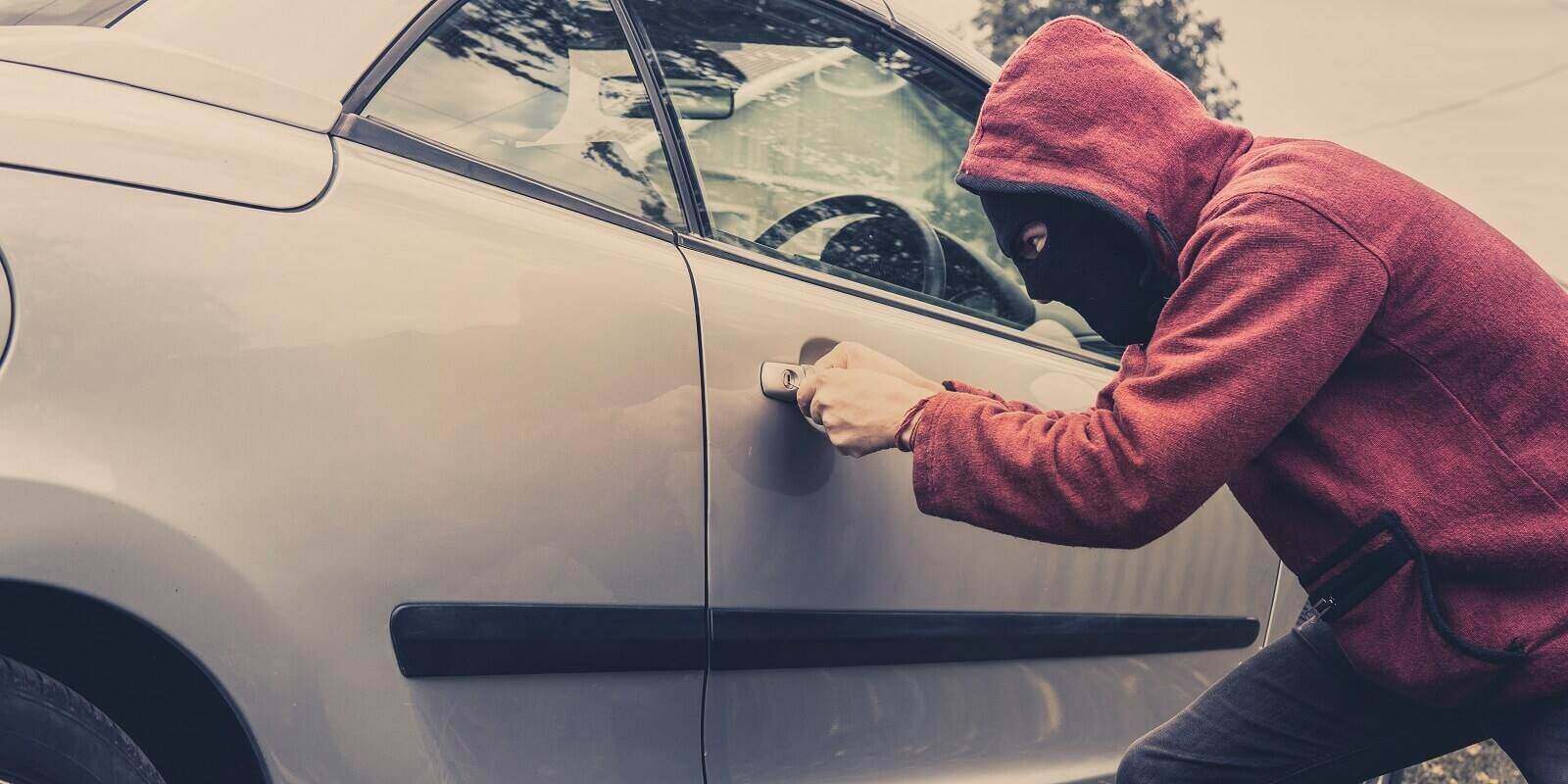 car being forced by a man in hoodie and mask