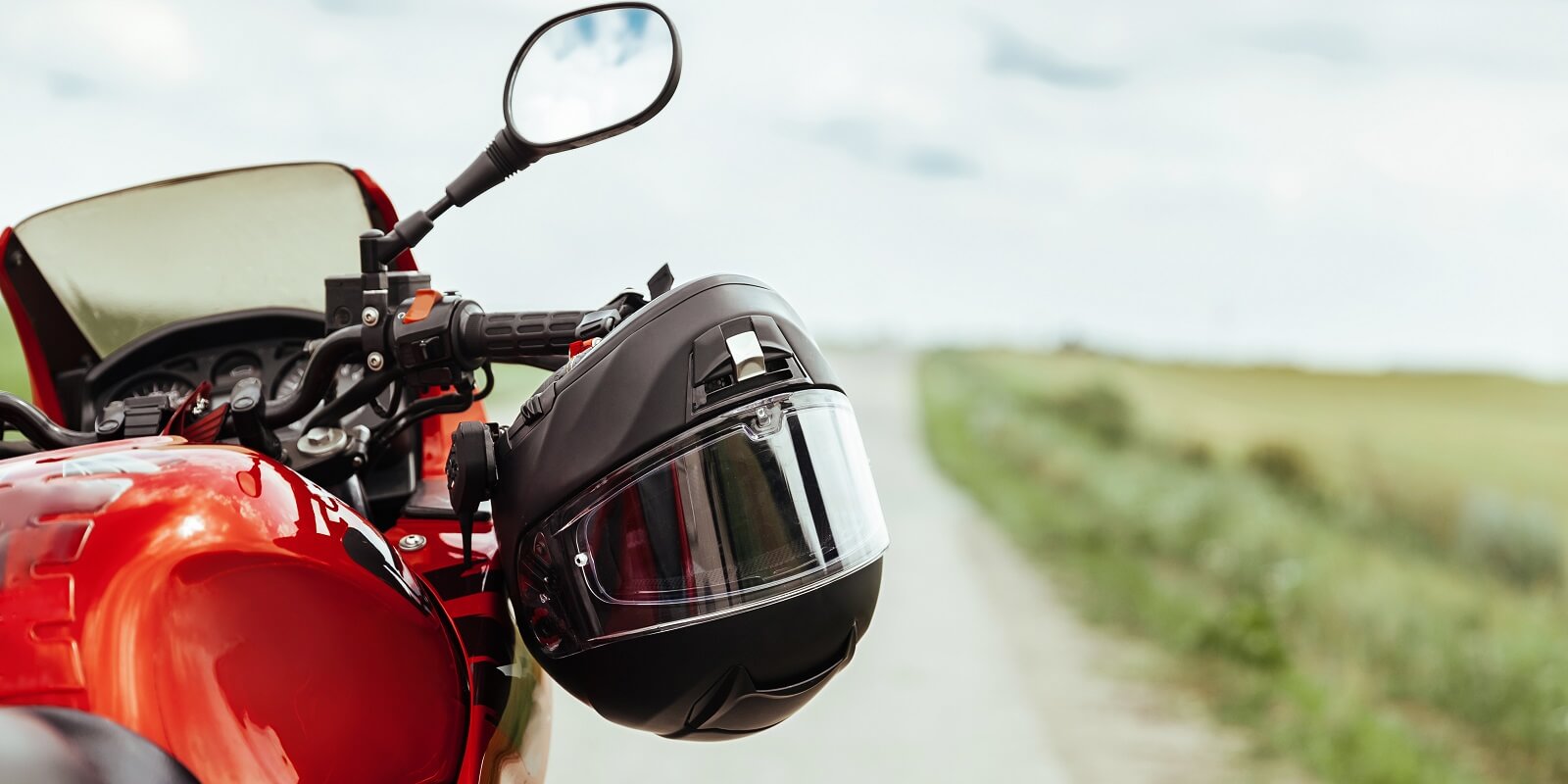 black motorcycle helmet hanging on the handlebars of the motorcycle