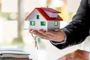 man holding house with keys
