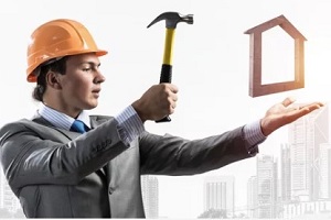 contractor with hammer and wood house