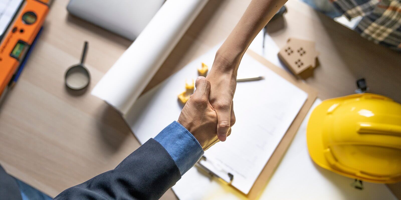 owner of home shaking hands after architect build home finish