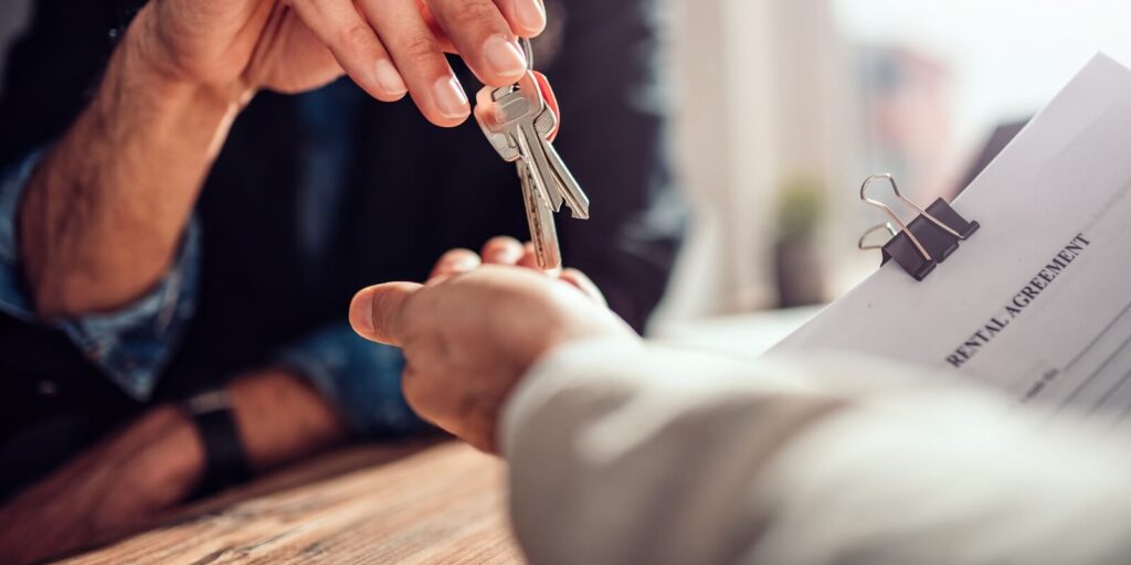 real estate agent passing keys to his client