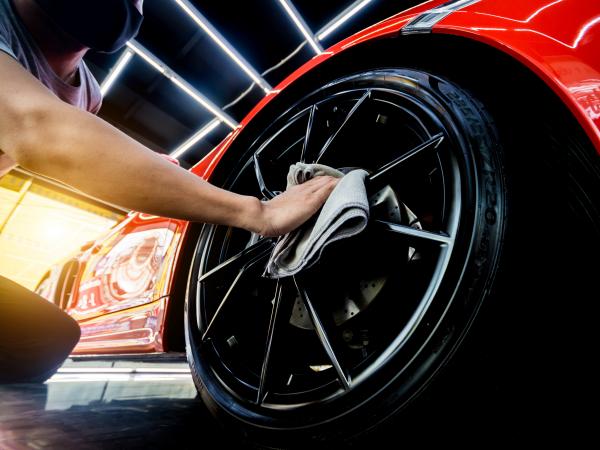 Car service worker polishing car wheels with microfiber cloth. Tools for polishing