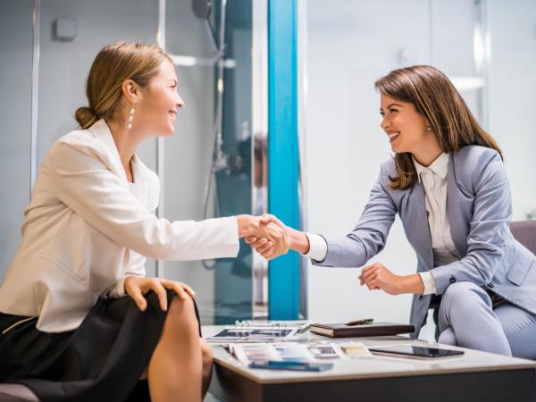 Businesswoman owning small business bath store. She is handshaking with a satisfied customer.
