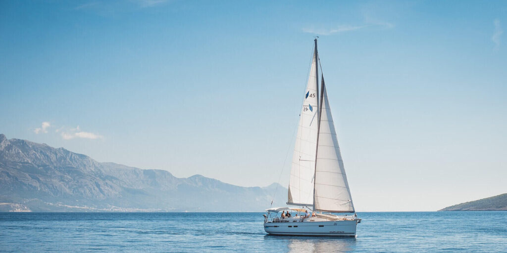 sailing yacht in the sea against the backdrop of mountains