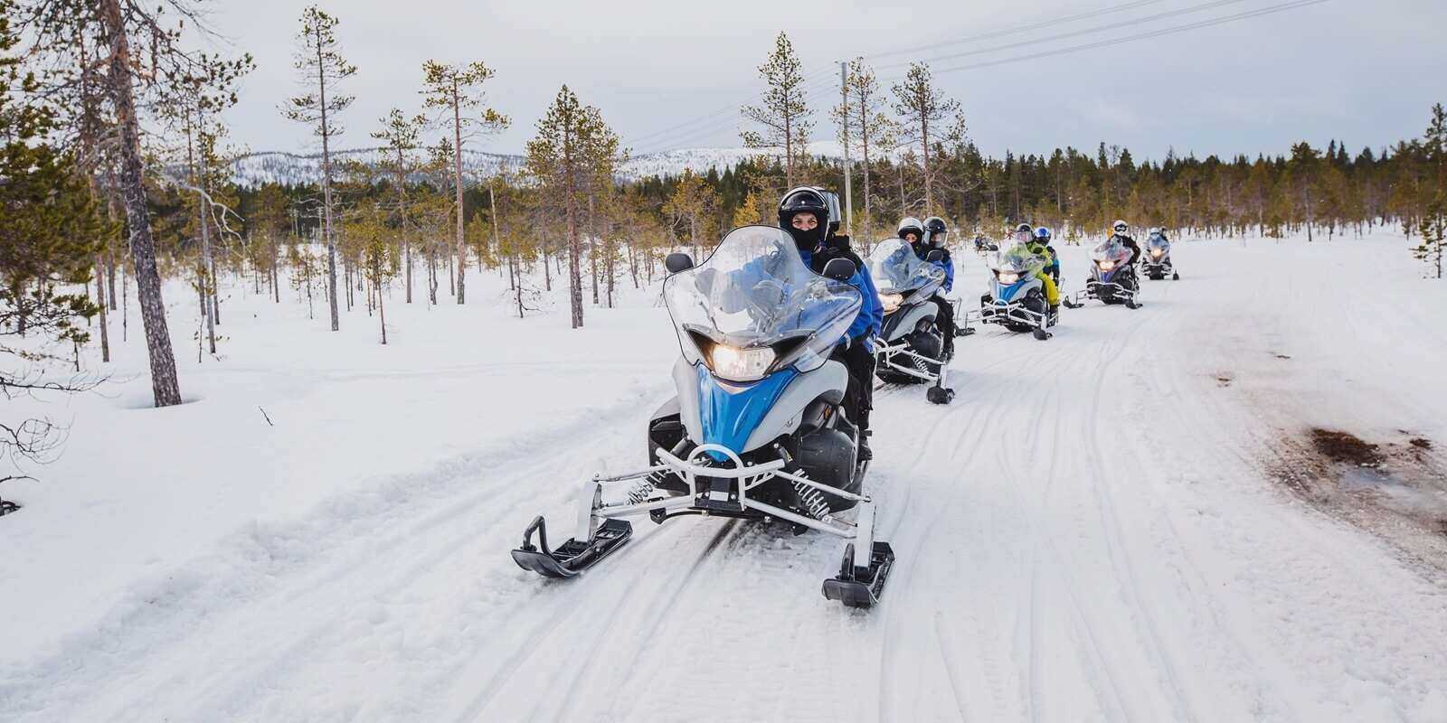 man driving snowmobile in finnish lapland
