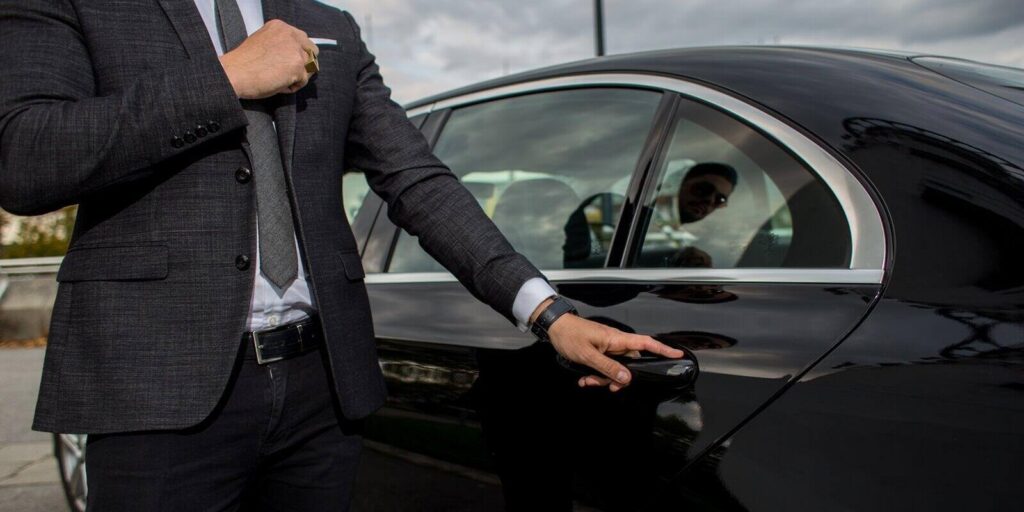 man opening a car limousine door