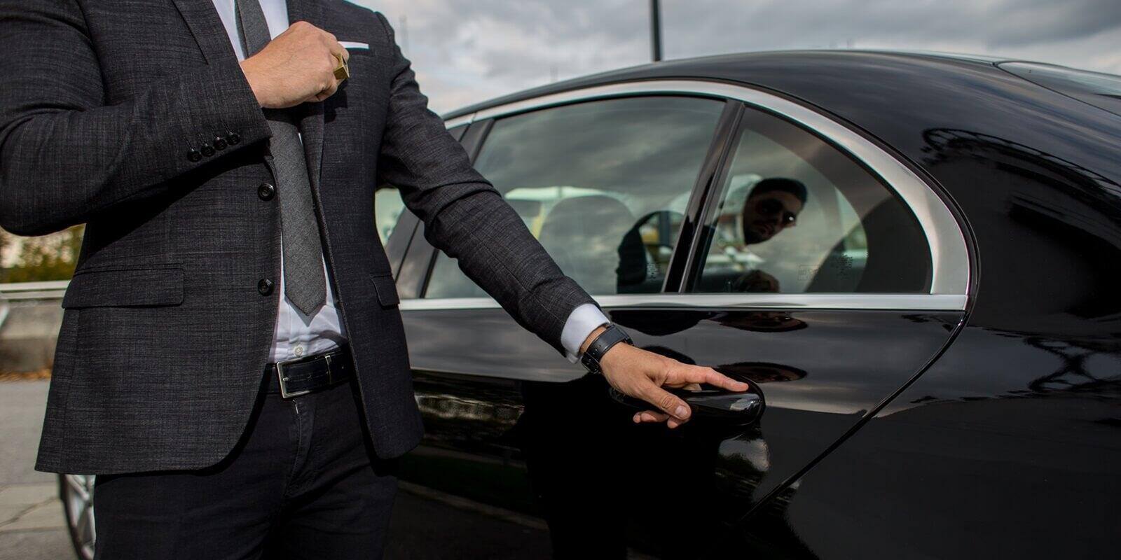 man opening a car limousine door