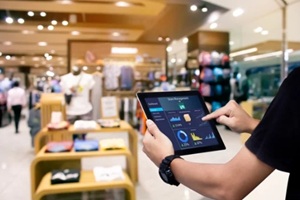 man using tablet in a busy retail store