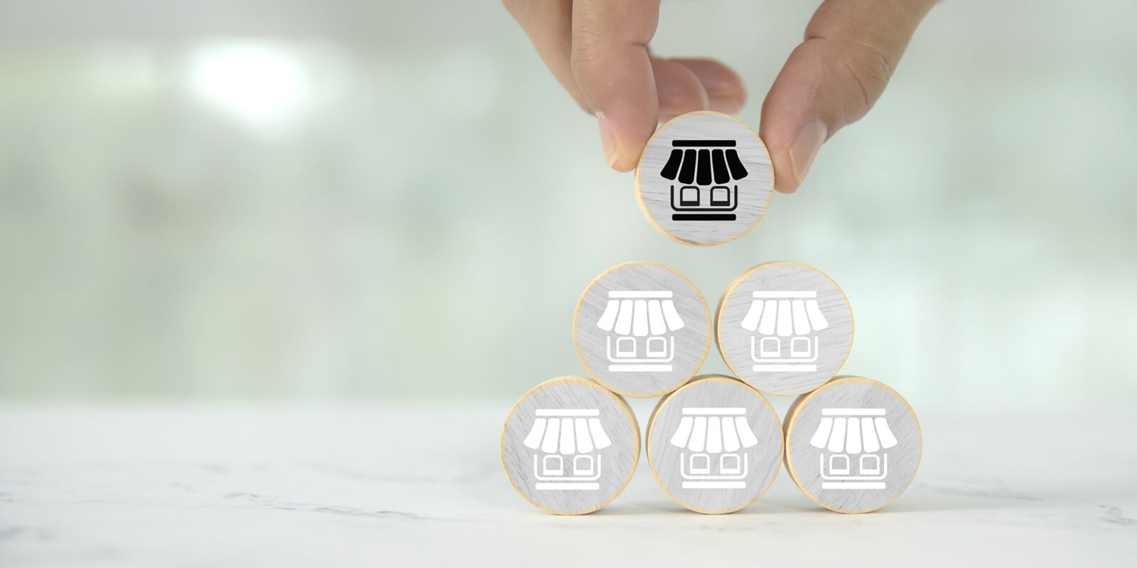 hand wooden toy stack in pyramid with franchise business store for franchising to growth branch expansion and business banking loan