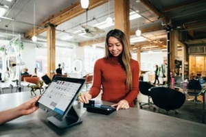 women making a payment after shopping in a retail store
