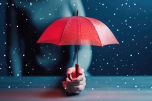 man holding red umbrella protecting people