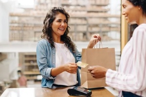 smiling women making payment at a retail store