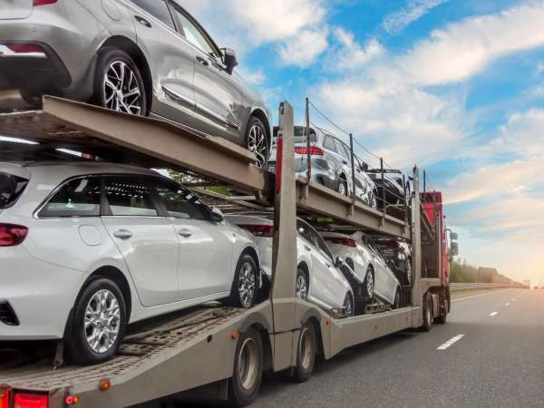 Transportation of new and very expensive cars. Hauling cars trailer and truck pulls rides on the highway