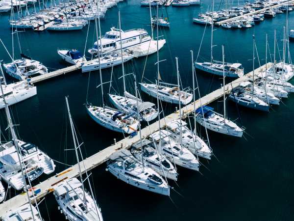 Aerial view of a lot of white boats and yachts moored in marina. Photo made by drone from above.
