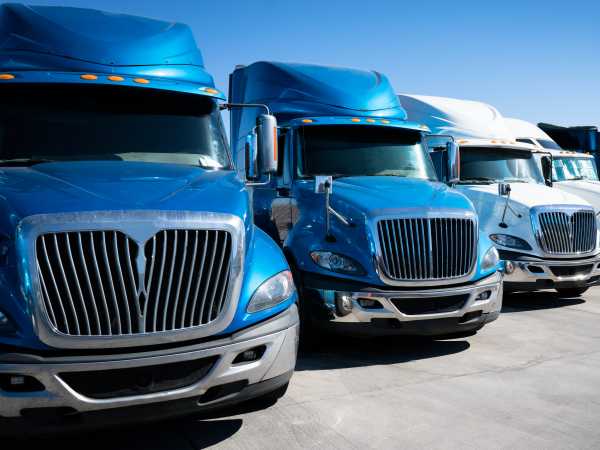 Fleet of blue 18 wheeler semi trucks