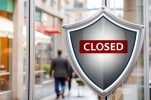image of a store with a shield and background of closed sign and financial documents