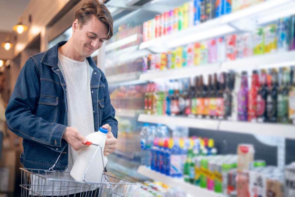 A man buys a bottle of milk from refrigerator cold in convenience store