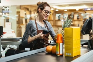 smiling female cashier scanning grocery items