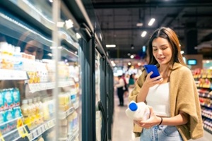 woman using mobile phone, shopping buying food and grocery at supermarket