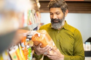 indian man shooing at a general store