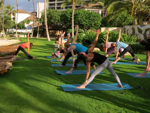 Group of people doing yoga outside at the beach