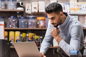Pet Shop Owner Checking Insurance Coverage on His Laptop